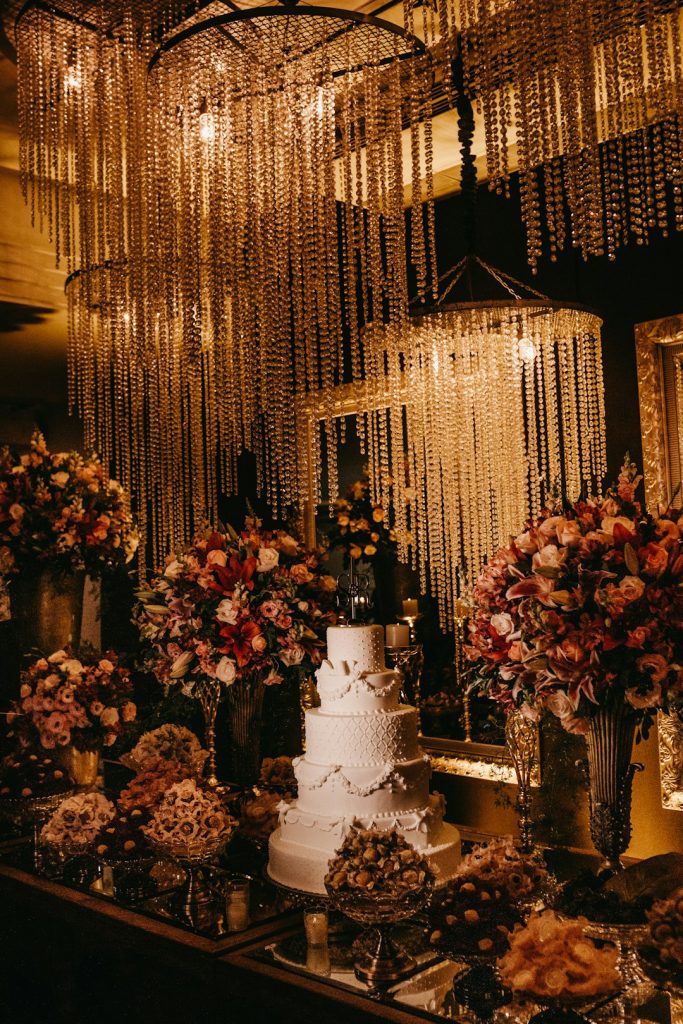 5-layer-wedding-cake-surrounded-with-assorted-color-flower-arrangement-with-lighted-chandeliers-b-r3rmjpese